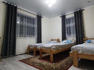 Postel nebo postele na pokoji v ubytování Tündük Guest House, Karakol