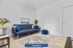 a living room with a blue couch and a rug at Burton on Trent - 3 Bedroom, Sleep 6, Wi-Fi - JRR Stays in Burton upon Trent