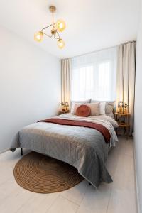 a bedroom with a large bed and a large window at Apartament Chopin - ścisłe centrum - by Kairos Apartments in Gliwice