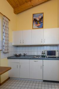 a kitchen with white cabinets and a microwave at Waldhauser Hof in Schönau am Königssee