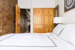 1 dormitorio con cama blanca y pared de ladrillo en 26-3B 1BR prime gramercy WD in unit Courtyard en Nueva York