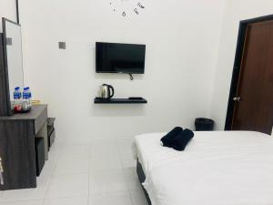 a hotel room with a bed and a tv on the wall at I-STAY 01 JK Roomstay in Kampong Bemban