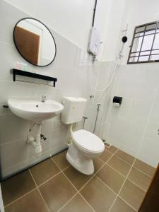bagno con servizi igienici, lavandino e specchio di I-STAY 01 JK Roomstay a Kampong Bemban