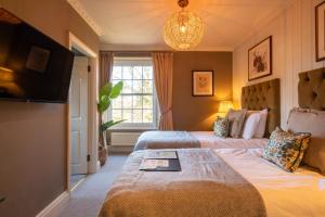 a hotel room with two beds and a television at Prince of Burford in Burford
