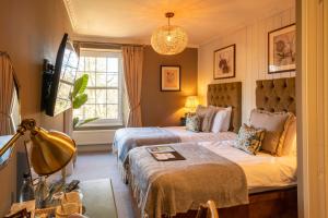 um quarto de hotel com duas camas e uma janela em Prince of Burford em Burford