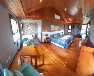 a bedroom with a bed and a table and chairs at Boutique Hotel & Spa Bosque del Nahuel in San Carlos de Bariloche