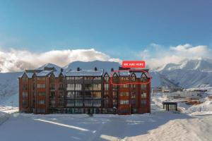a building in the snow with a sign on it at 4-Bedroom Luxury Apartment in New Gudauri in Gudauri