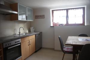 a kitchen with a sink and a stove and a table at Ferienwohnung Hiemer in Bad Grönenbach