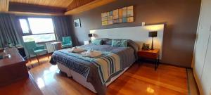 a bedroom with a bed and a table and chairs at Boutique Hotel & Spa Bosque del Nahuel in San Carlos de Bariloche