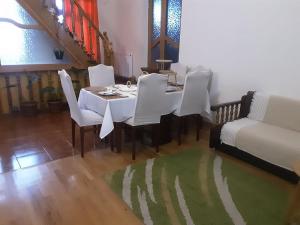 a dining room with a table and white chairs at Colchis ca777 in Kutaisi