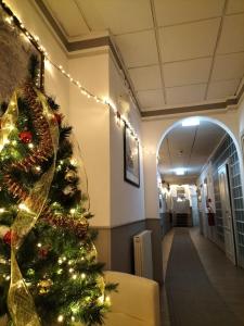 uma árvore de Natal num corredor de hospital com luzes em Hotel Camilla Firenze em Florença