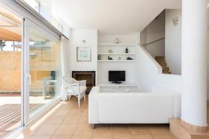 salon z białą kanapą i telewizorem w obiekcie Luxury villa in front of the beach ONA w mieście Calella de Palafrugell