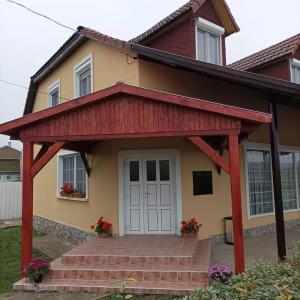 a house with a porch and a white door at Evita Vendégház in Sajókápolna