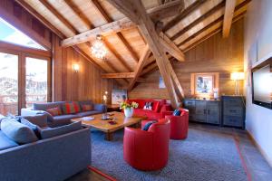 un soggiorno con sedie rosse e soffitto in legno di Appartement Noel Martin - 3 chambres a Les Deux Alpes