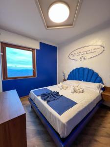 a blue bedroom with a large bed with a blue headboard at Rainbow Hotel Depandance Joli in San Marino