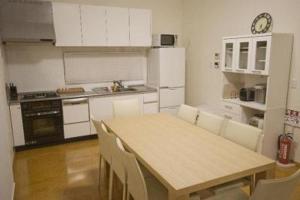Ruby Chalet في نيسيكو: مطبخ مع طاولة خشبية ودواليب بيضاء