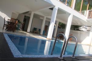 a house with a swimming pool in front of it at Binnacle Negombo in Negombo