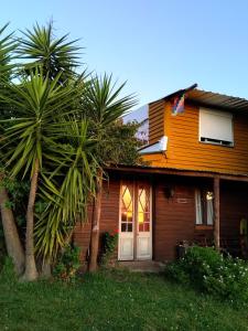 una casa con palmeras delante en El Encuentro - Casa para 12 personas en Maldonado