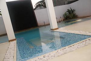 a pool in the middle of a building with blue water at Binnacle Negombo in Negombo