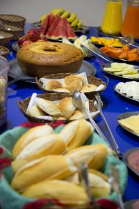 a table topped with plates of food with fruit at Hotel Pinheral Palace Hotel in Pinheiral