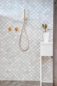 a bathroom with a shower with a white tiled wall at תניא in Gilon