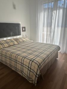 a bedroom with a bed with a plaid blanket on it at Civico 28 in Pescara