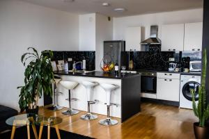 a kitchen with a counter with stools in it at HERMES APARTMENT & 2 free garage secured parkings in Ljubljana