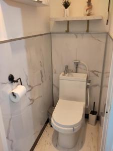 une salle de bain blanche avec toilettes et lavabo dans l'établissement Rétro Malo, à Dunkerque