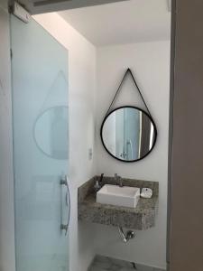a bathroom with a sink and a mirror at Pousada Litorânea in Saquarema