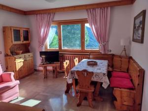 a living room with a table and chairs and a desk at CASA VIDI in Madonna di Campiglio