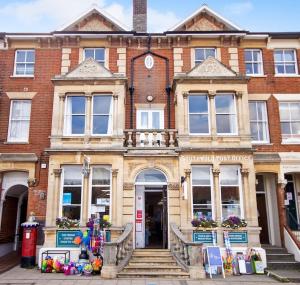 a large brick building with a staircase in front of it at High View, Southwold High Street (2 bed, 2 bath, allocated parking, balcony) in Southwold