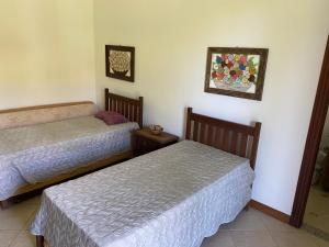 a bedroom with two beds and a picture on the wall at Casa de Campo sítio NSra Aparecida 