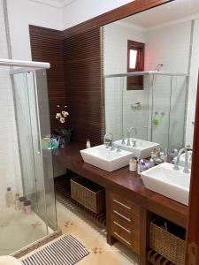 a bathroom with two sinks and a shower at Casa de Campo sítio NSra Aparecida 