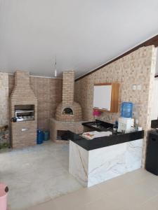 - une cuisine avec un mur en briques et un four à pizza dans l'établissement Villa Saudade, à Porto Seguro