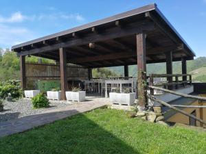 a wooden pavilion with a table and a fence at Tenuta MonteOliveto - Family Cottage - Agriturismo nelle Langhe in Vesime