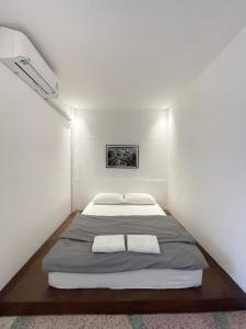 a white room with two beds in it at Chatel BKK in Bang Rak