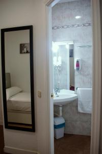 y baño con lavabo y espejo. en Hostal Ártico, en Madrid