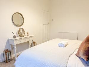a bedroom with a bed and a mirror on the wall at Attractive 3 Bedroom Apartment in Polmadie