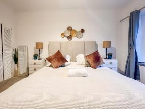 a bedroom with a large white bed with two lamps at Attractive 3 Bedroom Apartment in Polmadie