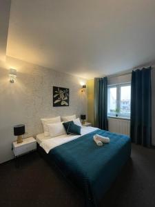 a bedroom with a large bed with a blue blanket at Inna Strefa - Sleep & Restaurant in Inowrocław