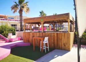 - un bar en bois avec une table et une chaise dans l'établissement Le Jardin d'EDEN "réservé aux couples", au Cap d'Agde