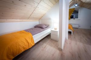 1 dormitorio con cama y techo de madera en Domki na Stoku, en Wisła