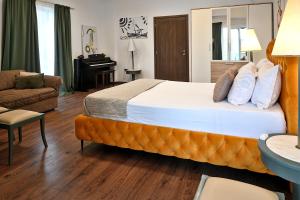 ein Hotelzimmer mit einem großen Bett und einem Klavier in der Unterkunft Stylish Apartment, Acropolis view in Athen