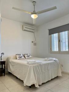 聖胡安的住宿－Duplex Céntrico TaLau，白色卧室配有一张带吊扇的床