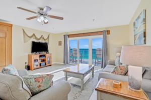 a living room with a couch and a tv at Sea Breeze 705 in St Pete Beach