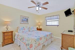 um quarto com uma cama e uma ventoinha de tecto em Sea Breeze 705 em St. Pete Beach
