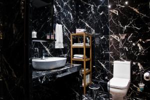 a black marble bathroom with a sink and a toilet at Stylish Apartment, Acropolis view in Athens