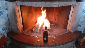 1 botella de vino y 2 copas frente a la chimenea en L' acero rosso en Miglianico