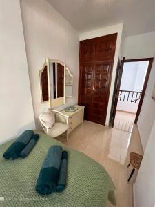 - une chambre avec un lit, un miroir et une chaise dans l'établissement Villa Sally, à Adeje