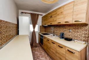 a kitchen with wooden cabinets and a white refrigerator at Bastasio airport skg in Tagarades